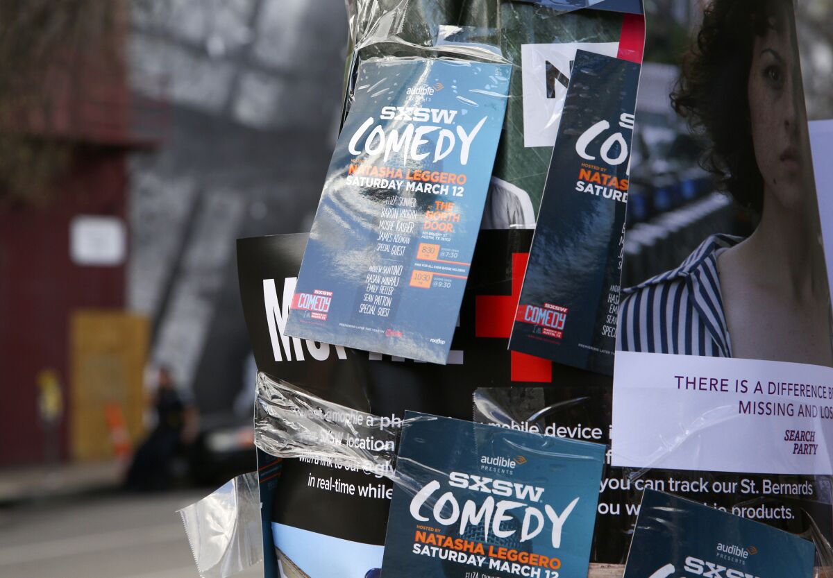 FILE - This March 12, 2016 file photo shows flyers advertising comedy on a light pole on Sixth Street during South By Southwest in Austin, Texas. Austin city officials have canceled the South by Southwest arts and technology festival. Mayor Steve Adler announced a local disaster as a precaution because of the threat of the novel coronavirus, effectively cancelling the annual event that had been scheduled for March 13-22. (Photo by Rich Fury/Invision/AP, File)