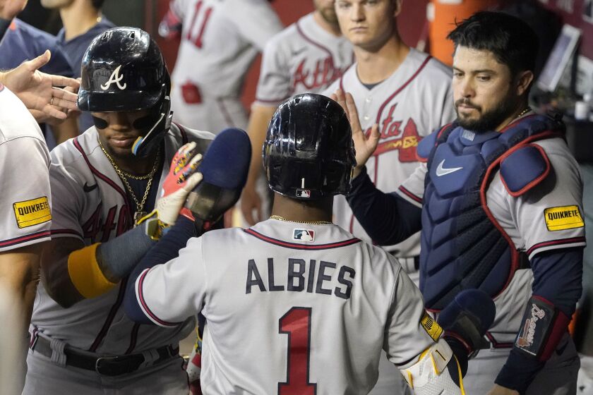 Atlanta Braves' Ozzie Albies is congratulated by teammates after scoring against the Arizona Diamondbacks during the second inning of a baseball game, Sunday, June 4, 2023, in Phoenix. (AP Photo/Darryl Webb)