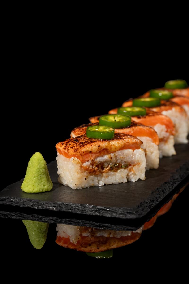 A line of sushi pieces with a dollop of wasabi