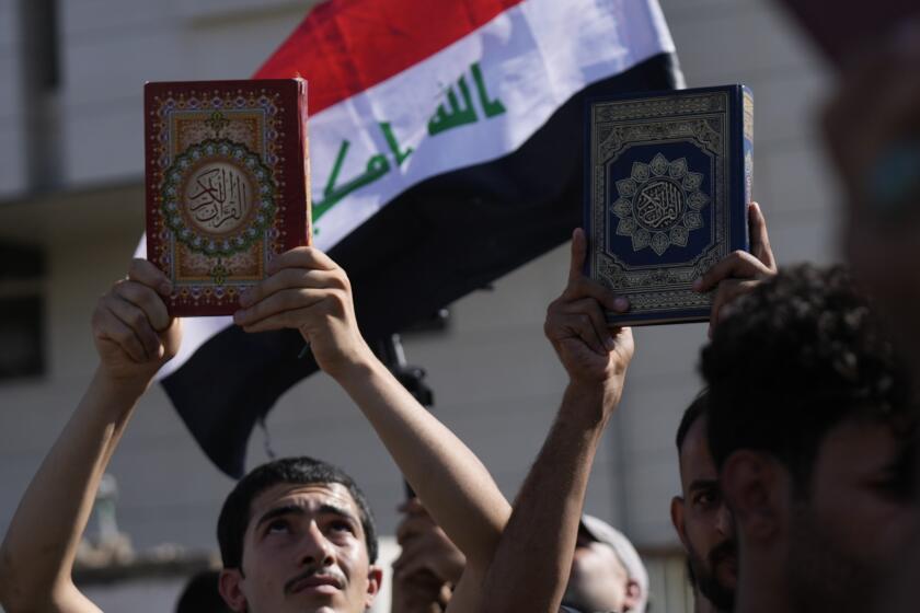 FILE - Supporters of the Shiite cleric Muqtada al-Sadr raise the Quran, the Muslims' holy book, during a demonstration in front of the Swedish Embassy in Baghdad, on June 30, 2023, in response to the burning of Quran in Sweden. Protesters angered by the burning of a copy of the Quran stormed the Swedish Embassy in Baghdad early Thursday, July 20, 2023, online videos purported to show. (AP Photo/Hadi Mizban, File)