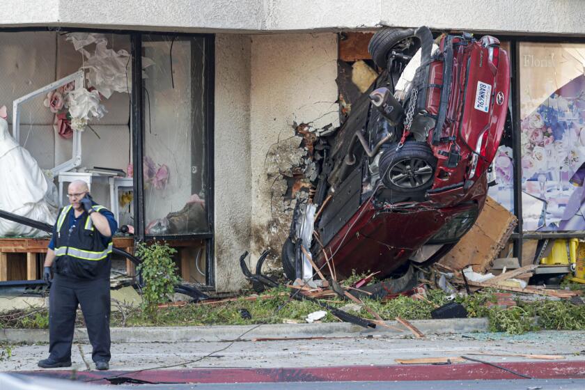 ARCADIA, CA - AUGUST 08, 2019 — The driver of a rental car was killed this morning in a single-vehicle crash in Arcadia, where the vehicle went airborne and ended up lodged in the window of a flower shop. A witness told police the vehicle was speeding westbound on Live Oak Avenue at Las Tunas Drive when the driver lost control, hit the center median and the vehicle became airborne and crashed into the business, according to the Arcadia Police Department. The vehicle, a red Hyundai Elantra, was a rental, police said. The age, gender and name of the victim was not disclosed. (Irfan Khan/Los Angeles Times)