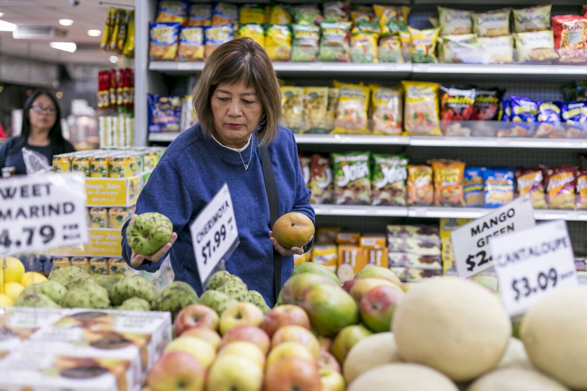 A customer picks fruit at a grocery store.