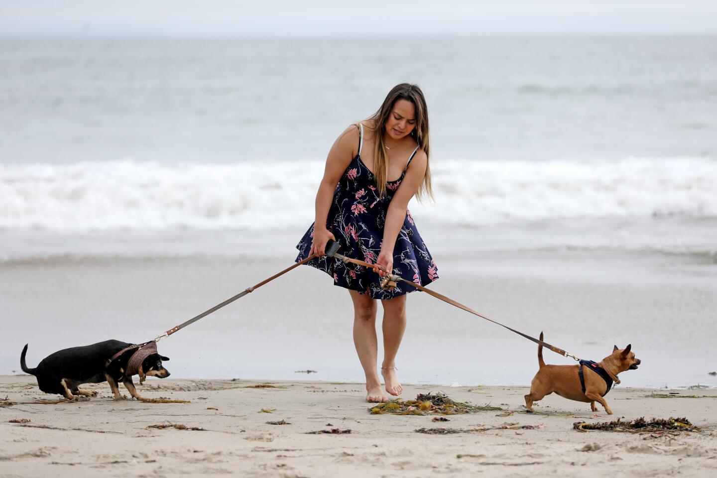 VENTURA, CA -- MAY 28: Mary Jasso-Brooks, of Ventura, with James, left, and Paige, walk along the surf at the beach on Thursday, May 28, 2020, in Ventura, CA. While many parks and beaches in Ventura County have been open for active use for weeks, Ventura city officials will begin to further ease restrictions at their outdoor spaces starting Friday. "Passive" activities such as sitting and sunbathing will be allowed "as long as the public maintains a safe physical distance of six feet and avoids congregating in large groups. (Gary Coronado / Los Angeles Times)