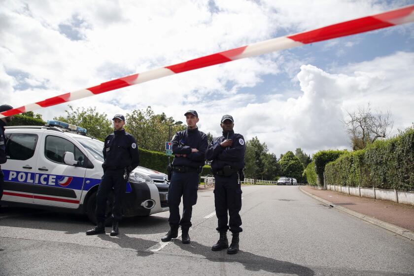 FILE - French police officers block the road leading to a crime scene the day after a knife-wielding attacker stabbed to death a senior police officer and his female companion Monday evening in Magnanville, west of Paris, France, Tuesday, June 14, 2016. A trial is opening in French counterterrorism court Monday Sept. 25, 2023 over the killing of two police officers in their home in 2016, in front of their 3-year-old son. (AP Photo/Thibault Camus, File)