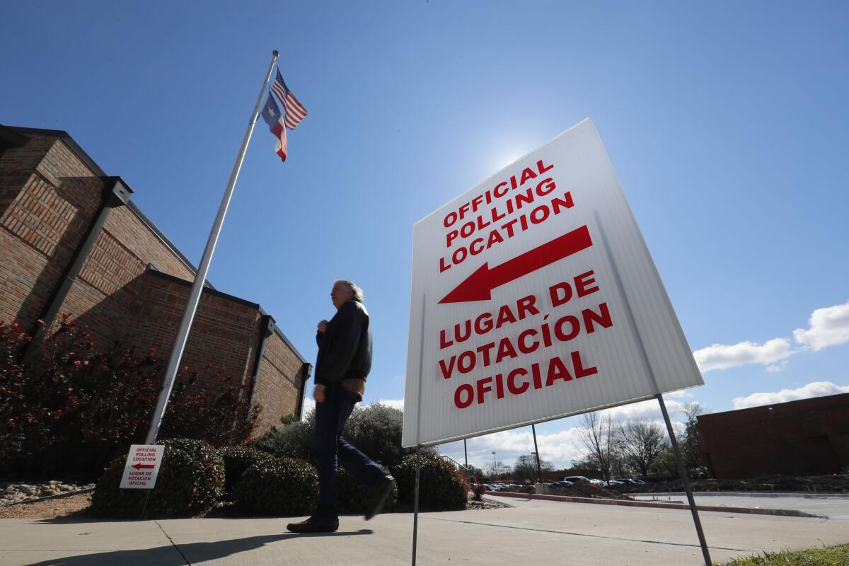 Un señalamiento con frases en inglés y español que dirige a los votantes a un centro electoral en Dallas.