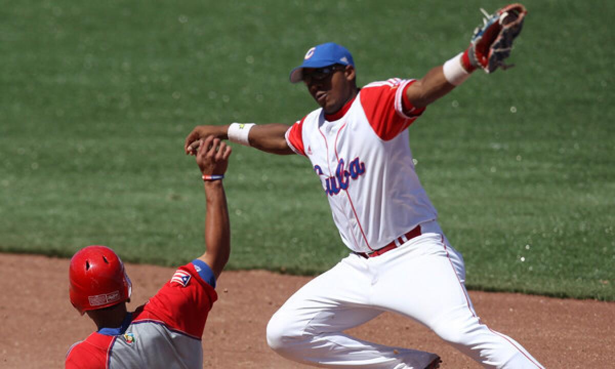 Puerto Rico's Reymond Fuentes slides safely in front of Cuba shotstop Erisbel Arruebarrena during a game at the 2011 Pan American Games in Mexico. Arruebarrena has signed with the Dodgers.