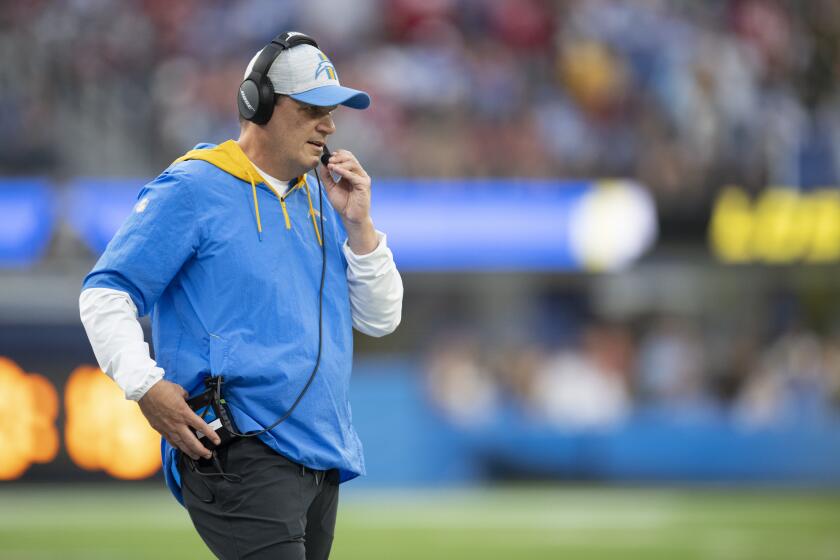 Chargers outside linebackers coach Giff Smith watches from the sideline while listening on a headset.