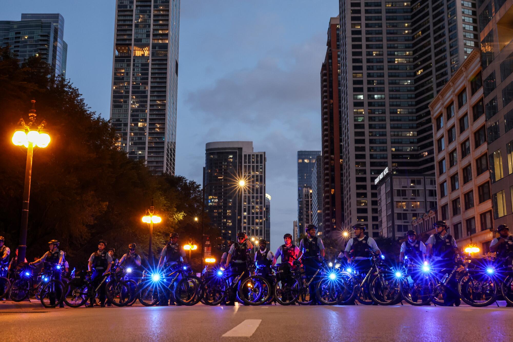 Una fila de policías en bicicleta con luces azules.