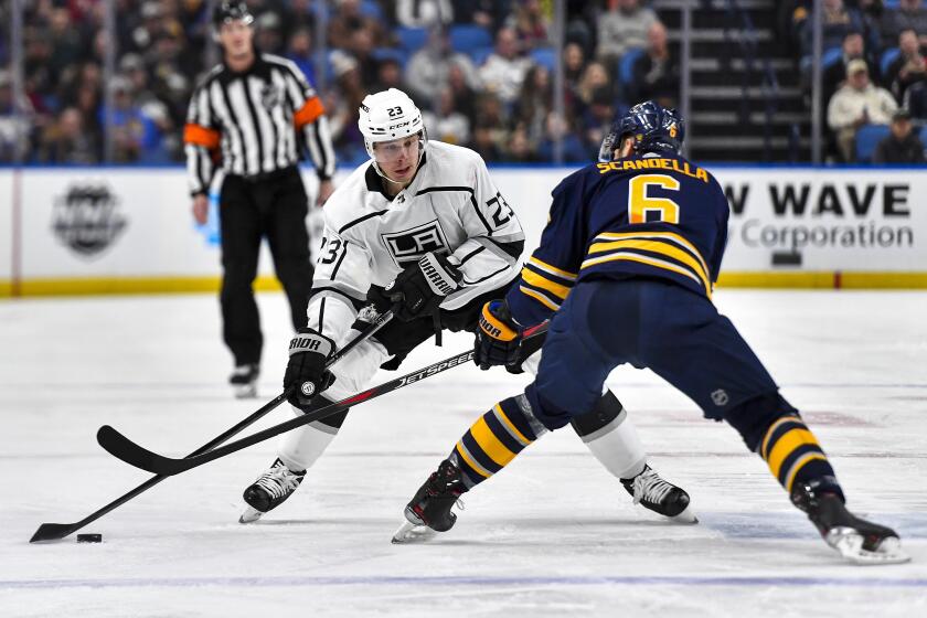 Kings right wing Dustin Brown works with the puck against Sabres defenseman Marco Scandella during the first period of a game Nov. 21.
