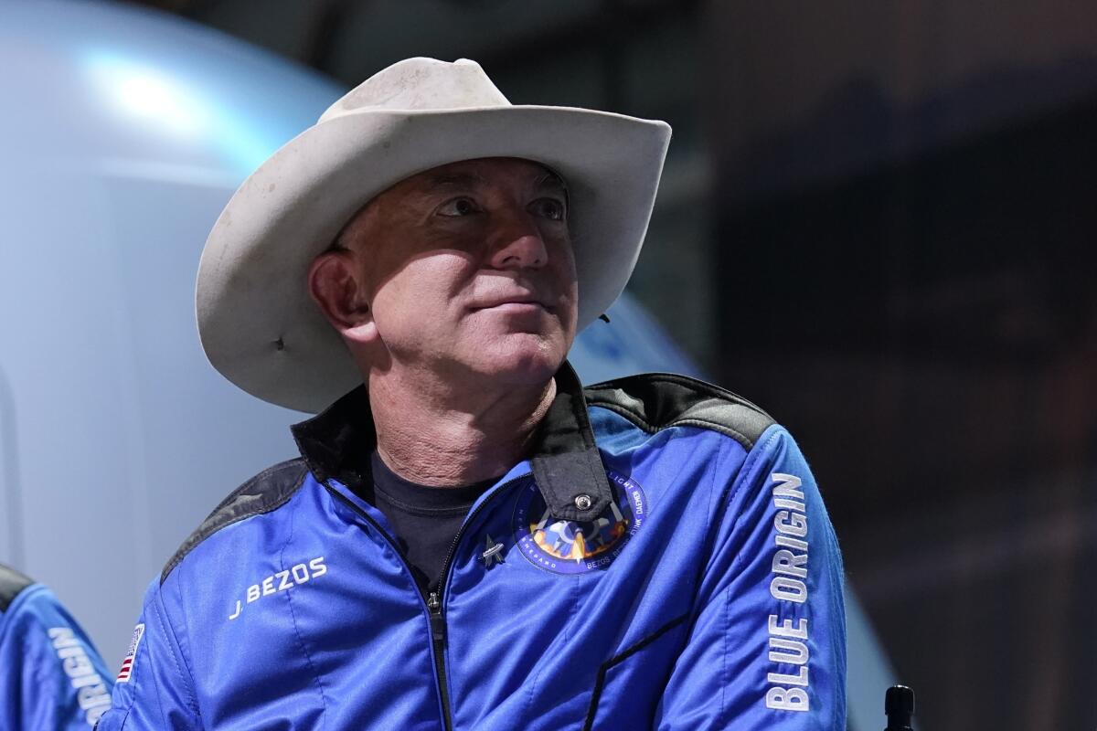 A man in a cowboy hat and Blue Origin jacket
