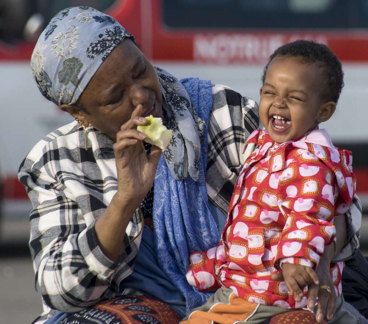 Sara, a 1-1/2-year-old migrant girl from Somalia, eats an apple in the arms of her grandmother at a refugee camp near Nickelsdorf, Austria, near the Hungarian border, on Wednesday.