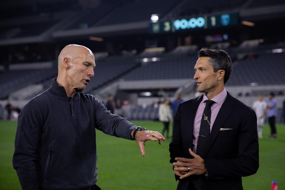 LAFC general manager John Thorrington speaks with coach Bob Bradley.