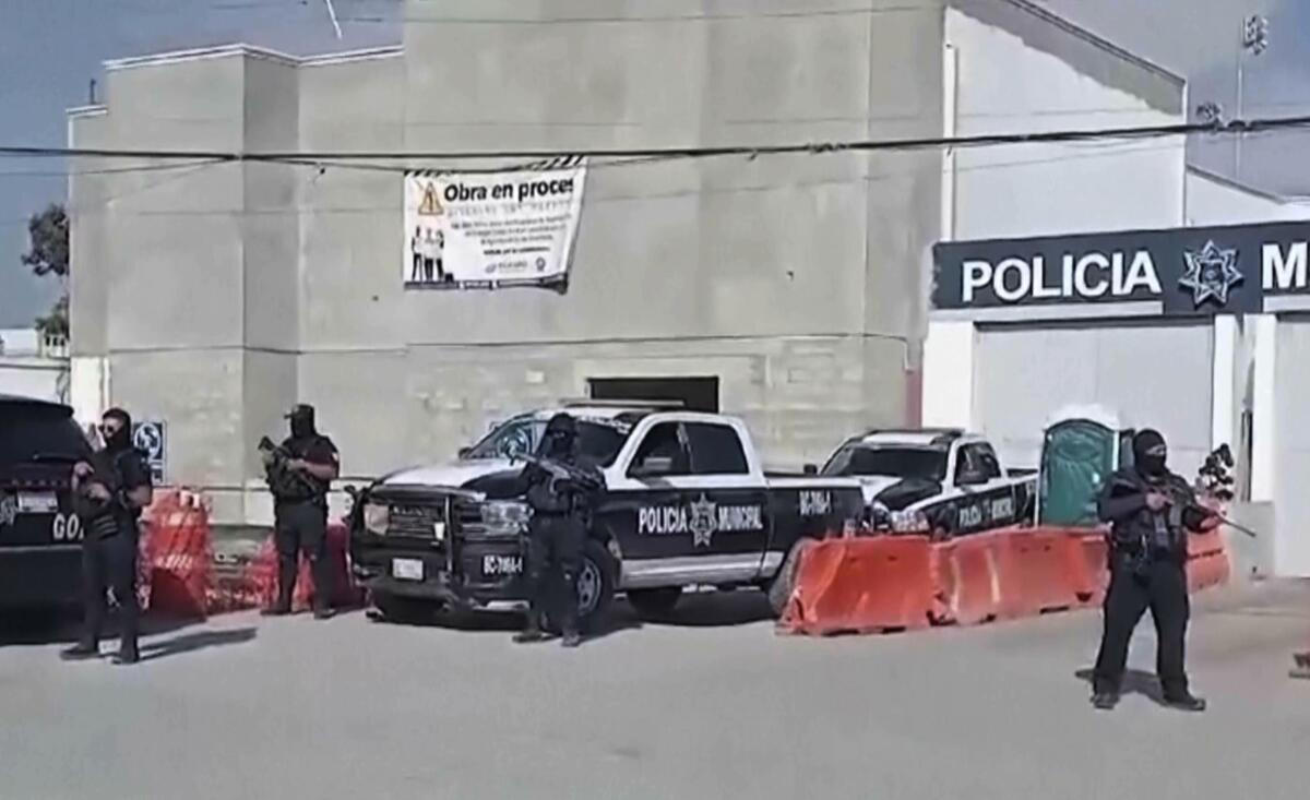 In this image made from video, police officers stand guard Thursday at the station in Ensenada, Mexico.