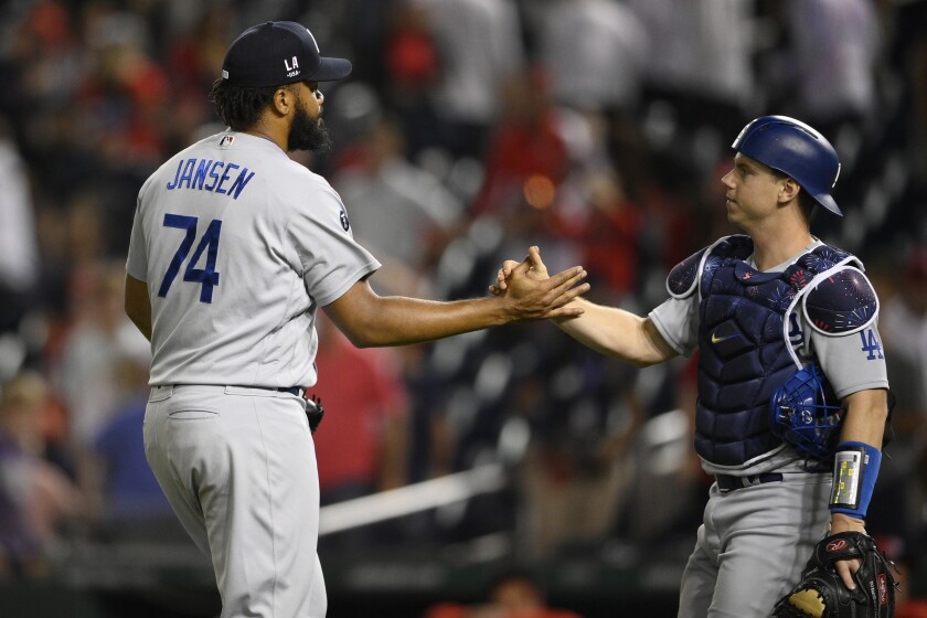 Los Angeles Dodgers relief pitcher Kenley Jansen (74) and catcher Will Smith, right, celebrate after a baseball game against the Washington Nationals, early Sunday, July 4, 2021, in Washington. The Dodgers won 5-3. (AP Photo/Nick Wass)