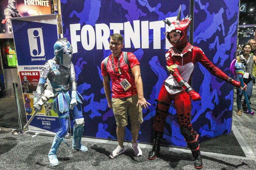 Hayne Palmour IV  U-T Braden Dunlap (center) dances with Fortnite’s Tricera Ops (right) and the Frozen Red Knight during Comic-Con International’s Preview Night.