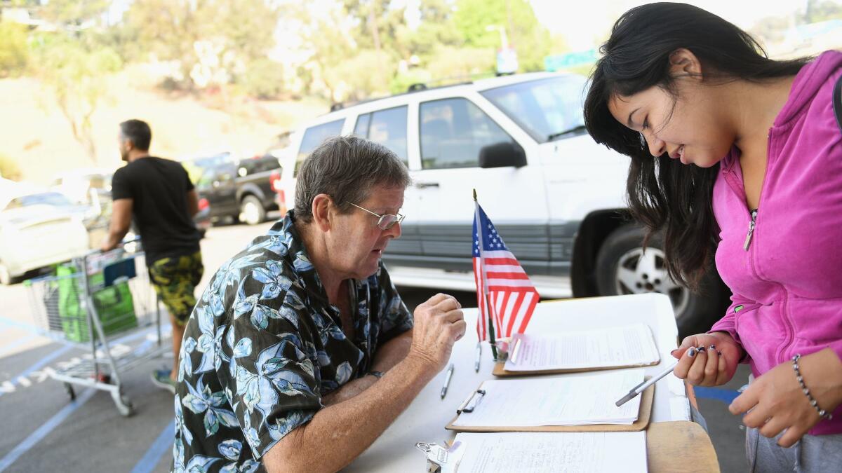 Tim Ecker collects signatures outside a Silver Lake grocery store in 2016.