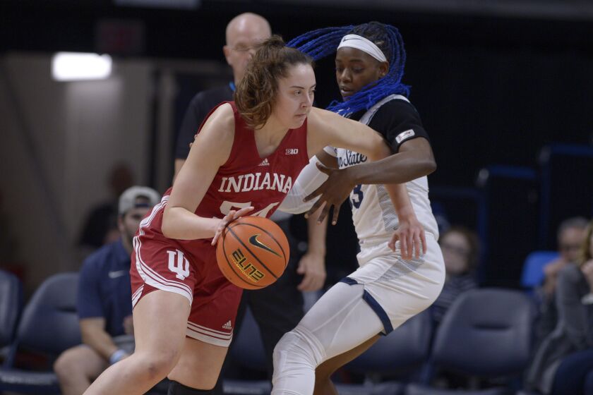 Indiana's Mackenzie Holmes, left, drives past Penn State's Taniyah Thompson during the first half of an NCAA college basketball game Thursday, Dec. 8, 2022, in State College, Pa. (AP Photo/Gary M. Baranec)