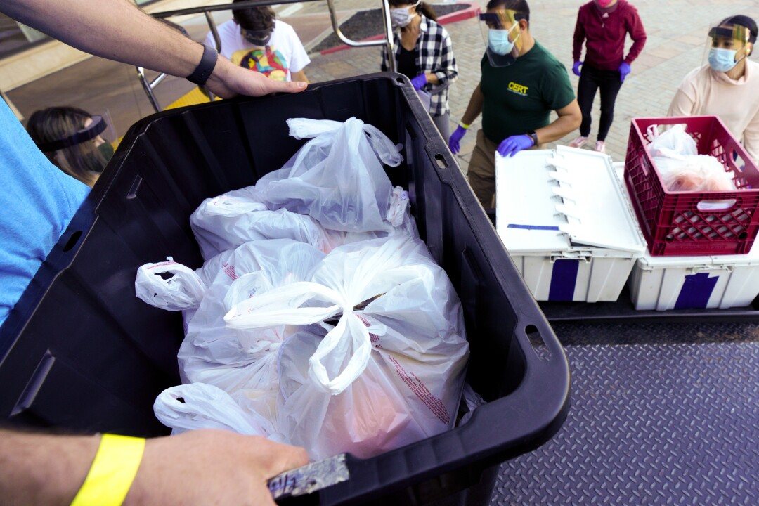 Standing on the back of the truck, Eitan Peled coordinates food deliveries with a group of volunteers.
