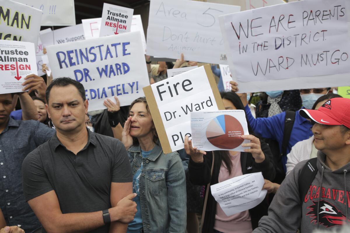 Community members divided over superintendent's employment hold signs at San Dieguito Union High School board meeting