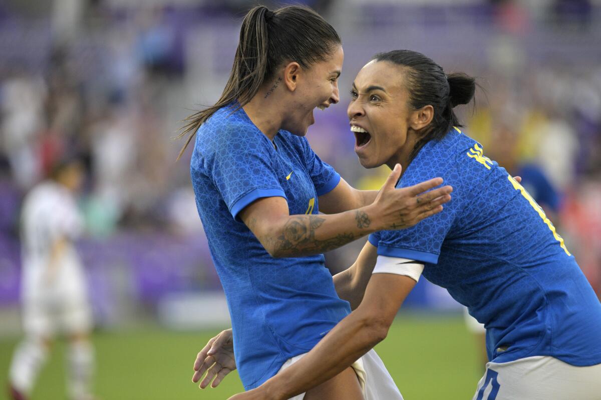 La delantera brasileña Debinha (izquierda) tras anotar un gol por la asistencia de Marta (derecha) 