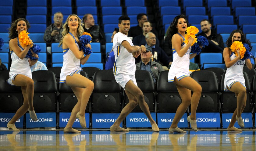 Devin Mallory, middle, performs with the UCLA dance team before the Bruins' game against Cal State Fullerton on Dec. 28 at Pauley Pavilion.