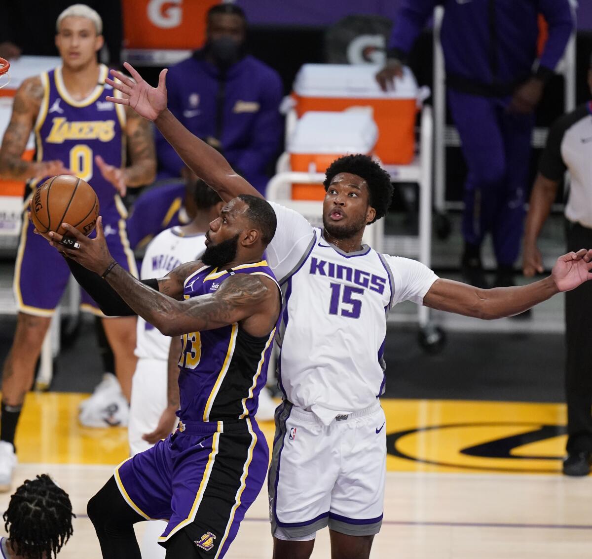 Lakers forward LeBron James scores past Kings center Damian Jones.