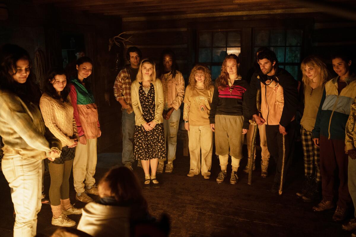 A large group of teenagers in a dark cabin