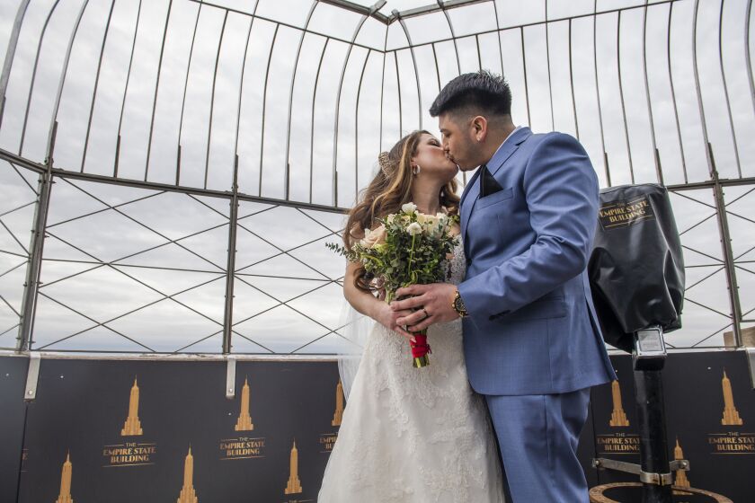 Kristine Mariana and Jorge Martinez pose for a portrait after getting married at the Empire State Building on Saturday Feb. 13, 2021, in New York. After getting engaged at the Empire State Building in 2018, the couple put their wedding on hold because of COVID-19. They were selected earlier in the week to hold their wedding at the same place where they were engaged. (AP Photo/Brittainy Newman)