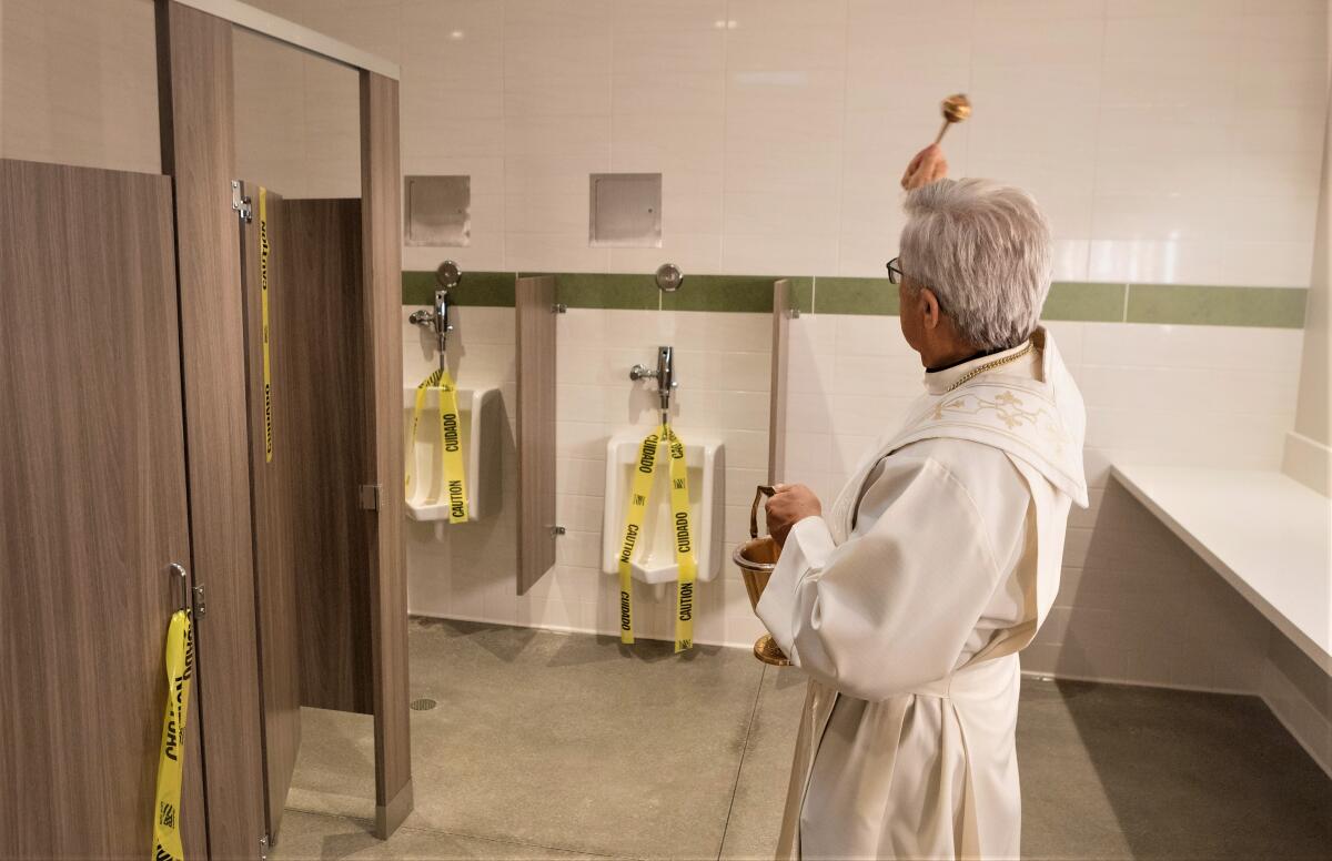 Fr. Mike Hanifin blesses the new restrooms at Saint Joachim Catholic Church in Costa Mesa, which took years to fund.