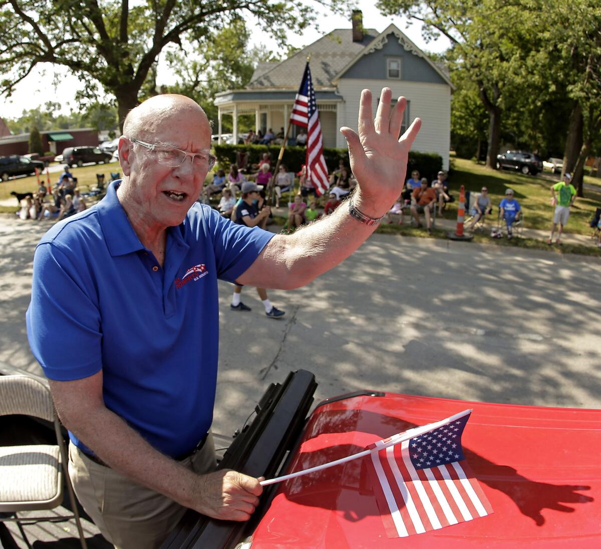 U.S. Sen. Pat Roberts waves to the crowd as he rides on the back of a pickup in a parade Saturday in Gardner, Kan. Roberts is facing tea party-backed challenger Milton Wolf in the primary election Tuesday.