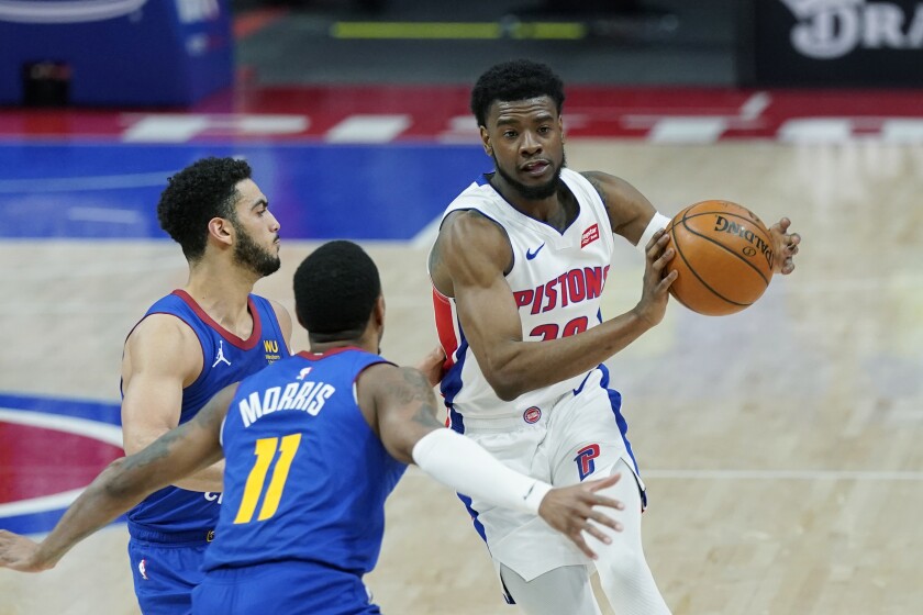 Detroit Pistons guard Josh Jackson passes as Denver Nuggets guard Monte Morris (11) and guard Markus Howard defend during the second half of an NBA basketball game, Friday, May 14, 2021, in Detroit. (AP Photo/Carlos Osorio)