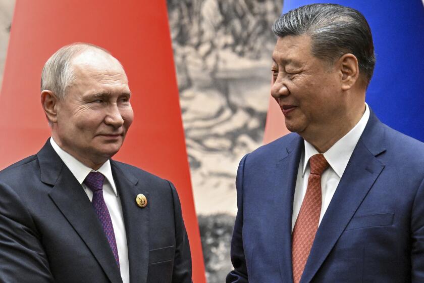 Chinese President Xi Jinping, right, and Russian President Vladimir Putin look toward each other as they shake hands prior to their talks in Beijing, China, on Thursday, May 16, 2024. (Sergei Bobylev, Sputnik, Kremlin Pool Photo via AP)
