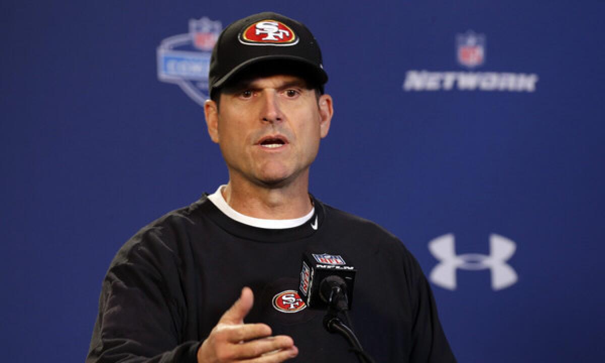 San Francisco 49ers Coach Jim Harbaugh answers questions during a news conference at the NFL scouting combine in Indianapolis on Thursday.