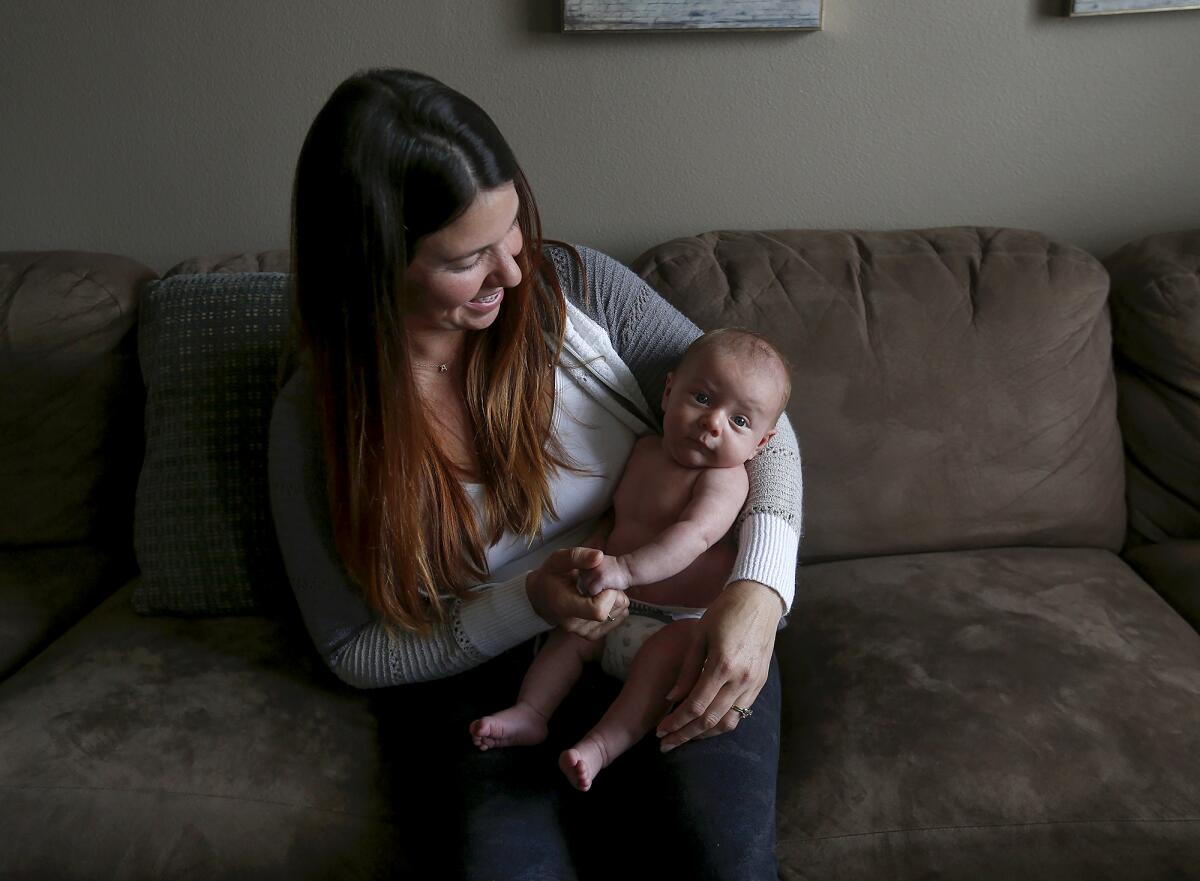 Kaitlyn Ramos, a client of registered nurse and lactation consultant Rachelle King, holds 6-week-old son Bowen.