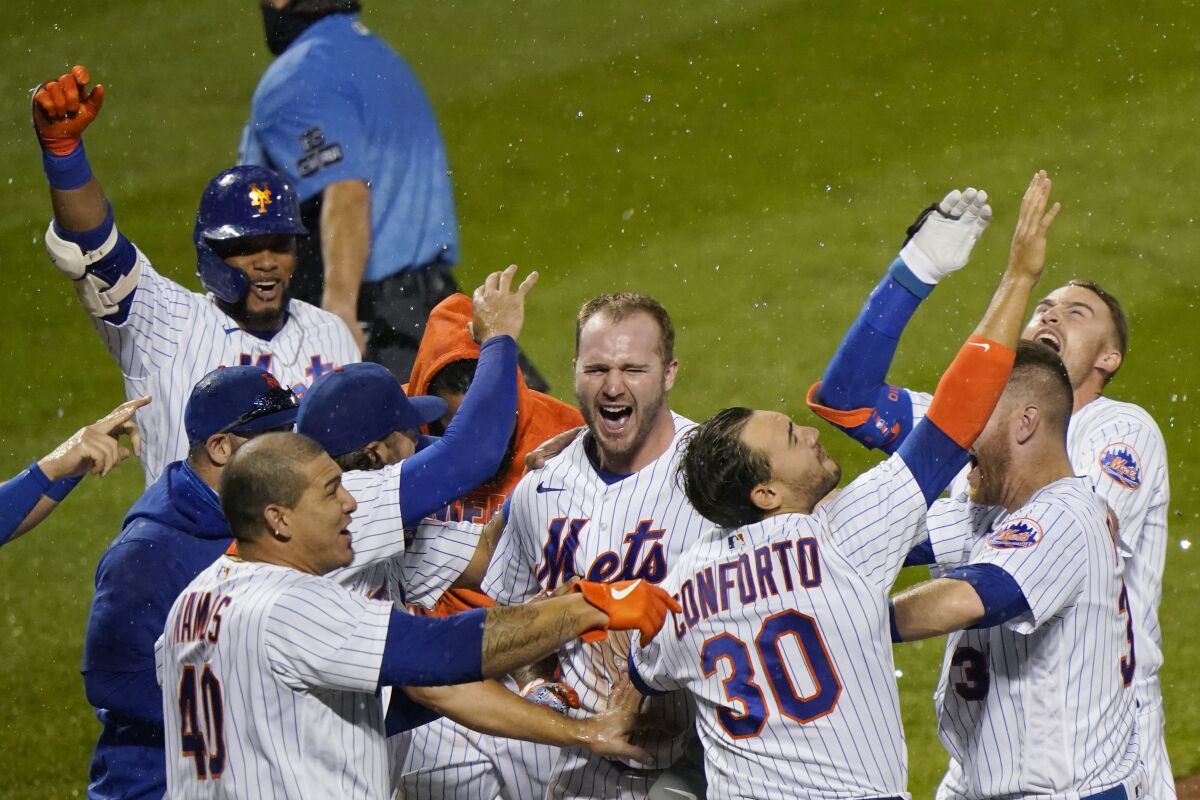 New York Mets' Pete Alonso, center, and teammates celebrate after Alonso hit a two-run home run during the 10th inning of the team's baseball game against the New York Yankees, Thursday, Sept. 3, 2020, in New York. (AP Photo/Kathy Willens)