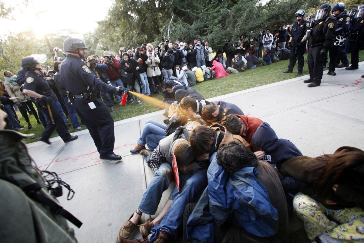 UC Davis Police Lt. John Pike uses pepper spray on Occupy protesters. A university report on the Nov. 18, 2011, incident declared that the pepper-spraying violated policy.