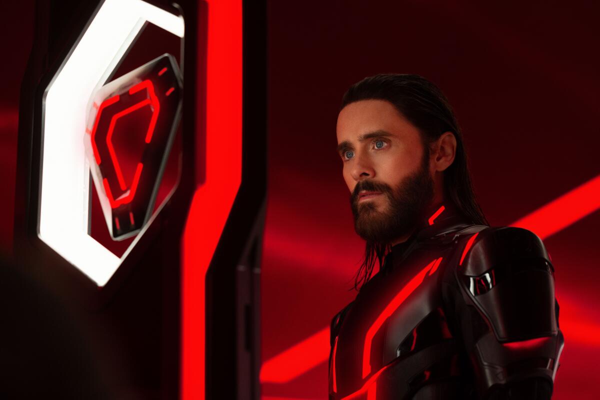 杰瑞德·莱托 (Jared Leto) 身穿未来派紧身衣,看着一个漂浮的三角形