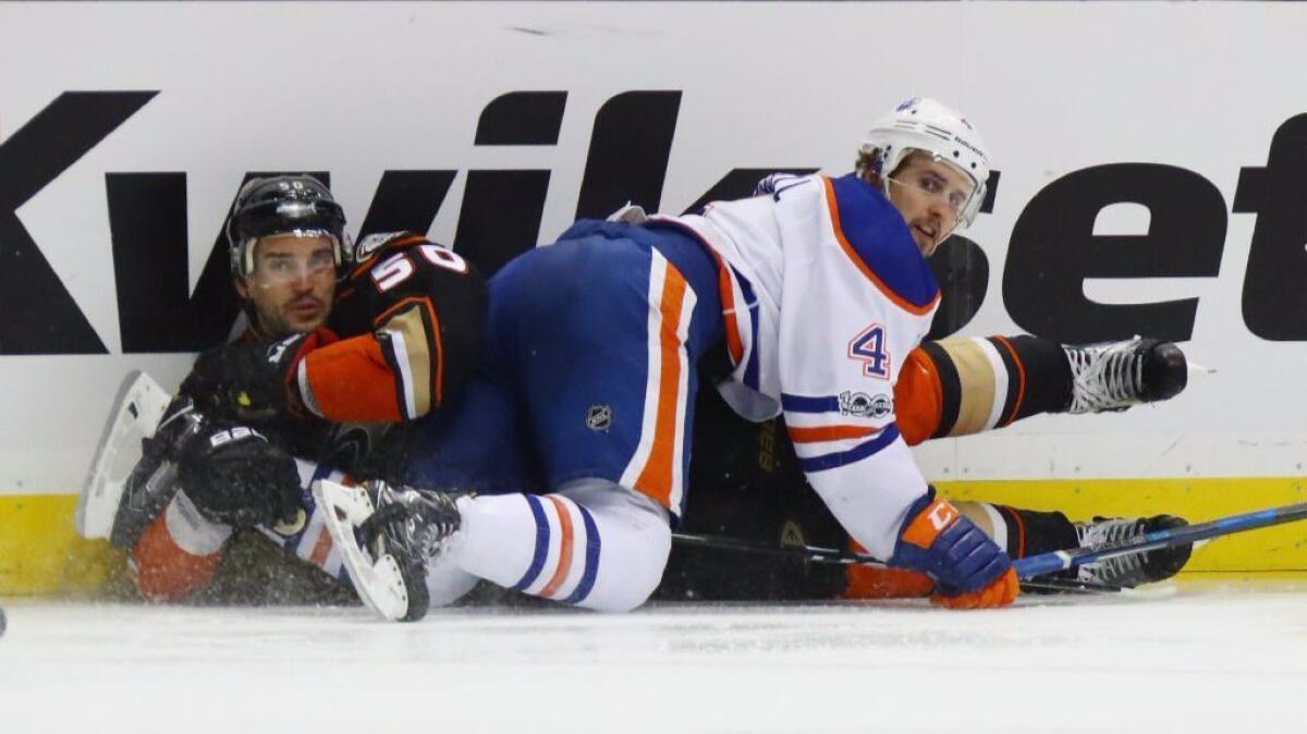 Oilers defenseman Kris Russell and Ducks forward Antoine Vermette get tangled up during the third period of a game at Honda Center on Jan. 25.