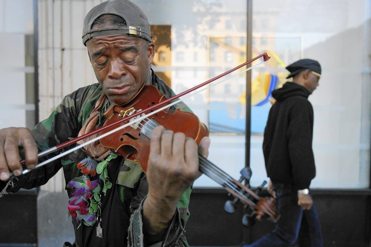 Nathaniel Ayers, playing his violin on 4th Street in downtown L.A., is adamantly opposed to forced medication and believes he can function well without it, despite a psychiatrist's testimony to the contrary.
