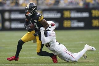 Pittsburgh Steelers wide receiver George Pickens gets tackled by Arizona Cardinals cornerback Divaad Wilson, right, during the first half of an NFL football game, Sunday, Dec. 3, 2023, in Pittsburgh. (AP Photo/Matt Freed)