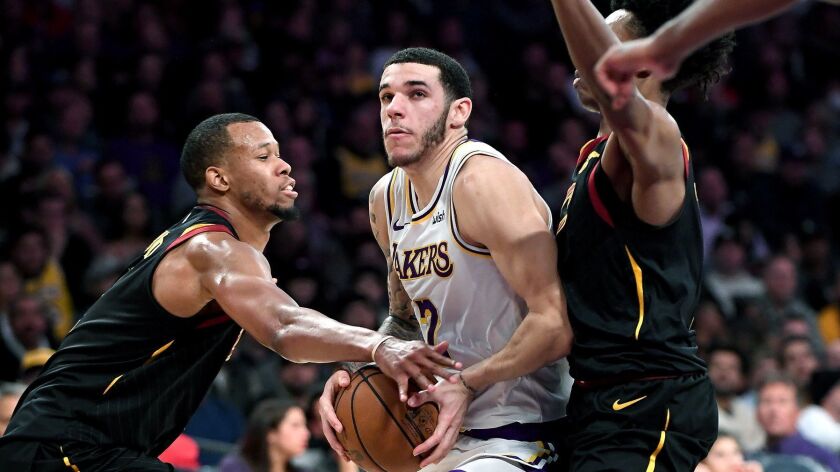 Lakers' Lonzo Ball drives past Cleveland Cavaliers' Rodney Hood, left, and Colin Sexton at Staples Center on Sunday.