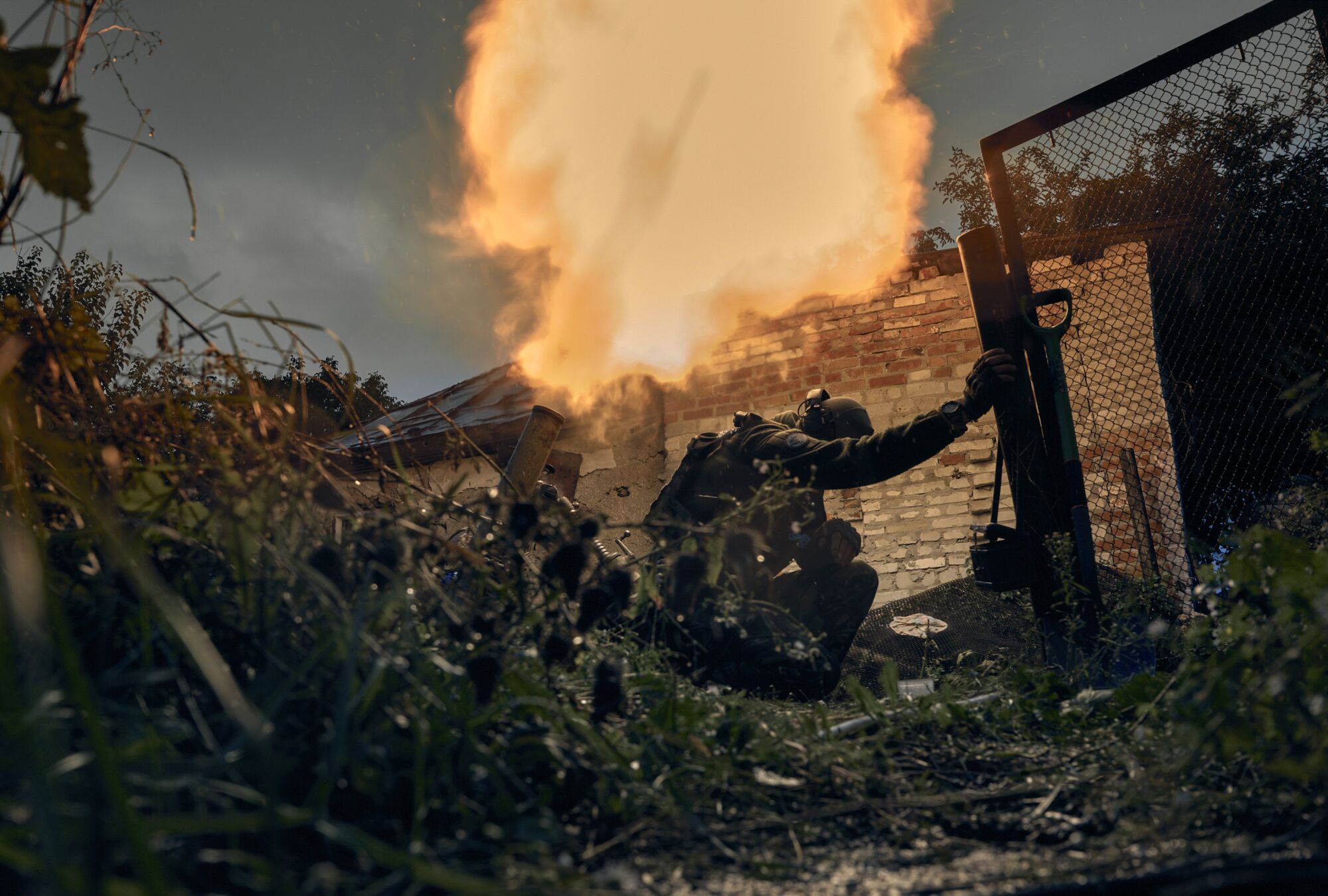 Украинский солдат стоит на коленях и склоняет голову во время стрельбы 