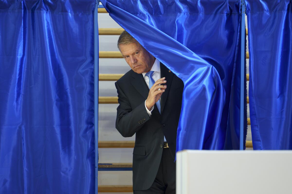 Romanian President Klaus Iohannis exits a voting cabin in Bucharest, Romania.