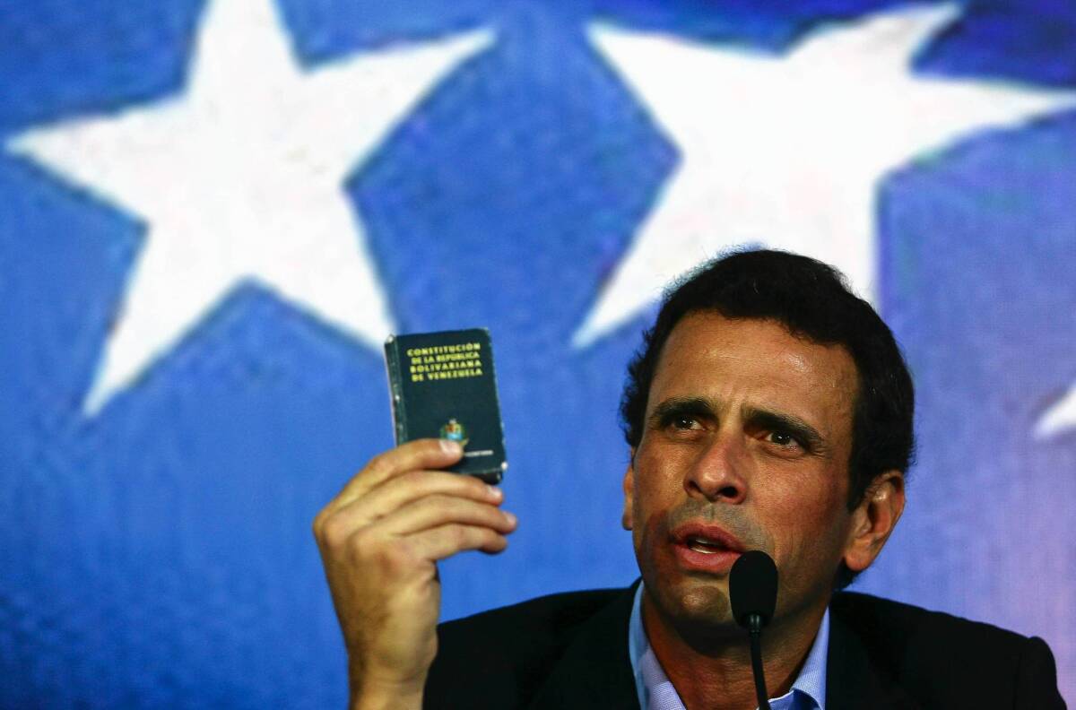 Venezuelan opposition leader Henrique Capriles holds a copy of the constitution at a gathering in Caracas last week.