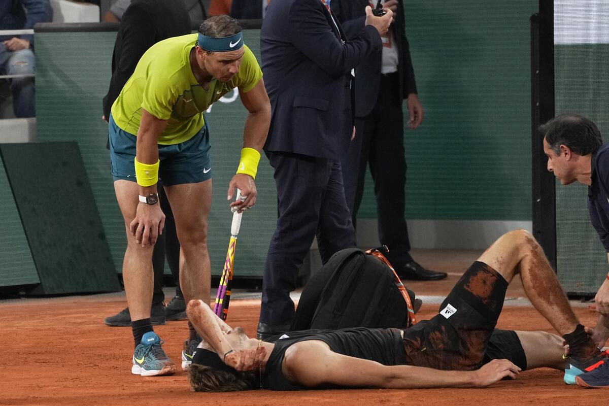 Rafael Nadal checks on Alexander Zverev after he fell to the court during their French Open semifinal Jne 3, 2022.