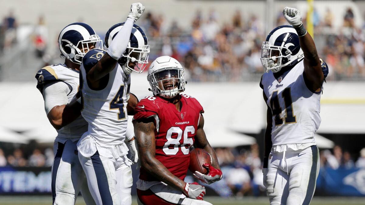 Rams defensive backs John Johnson (43) and Marqui Christian (41) celebrate after stopping Arizona Cardinals tight end Ricky Seals-Jones (86) short of the first down in the second half at the Coliseum on Sept. 16, 2018. Rams won 34-0.