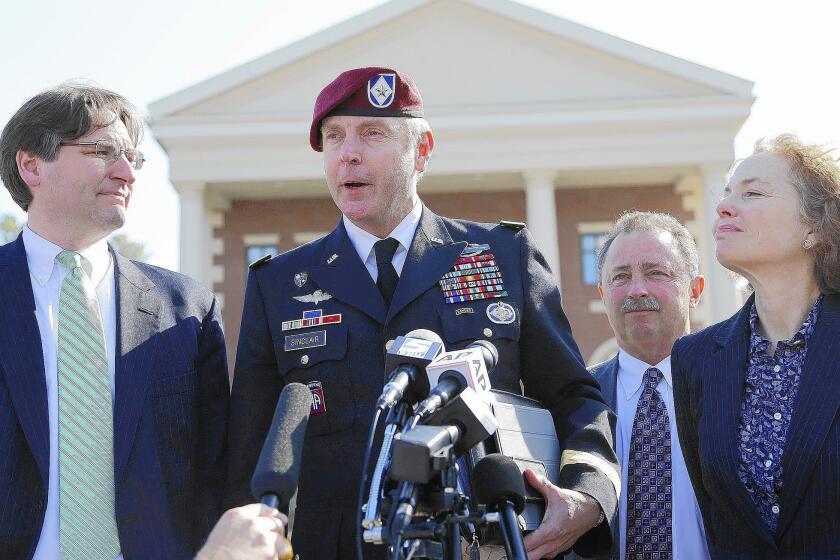 Army Brig. Gen. Jeffrey A. Sinclair, surrounded by his attorneys, makes a statement to reporters after his sentencing at Ft. Bragg, N.C. He and his legal team appeared taken aback by the relatively lenient sentence.