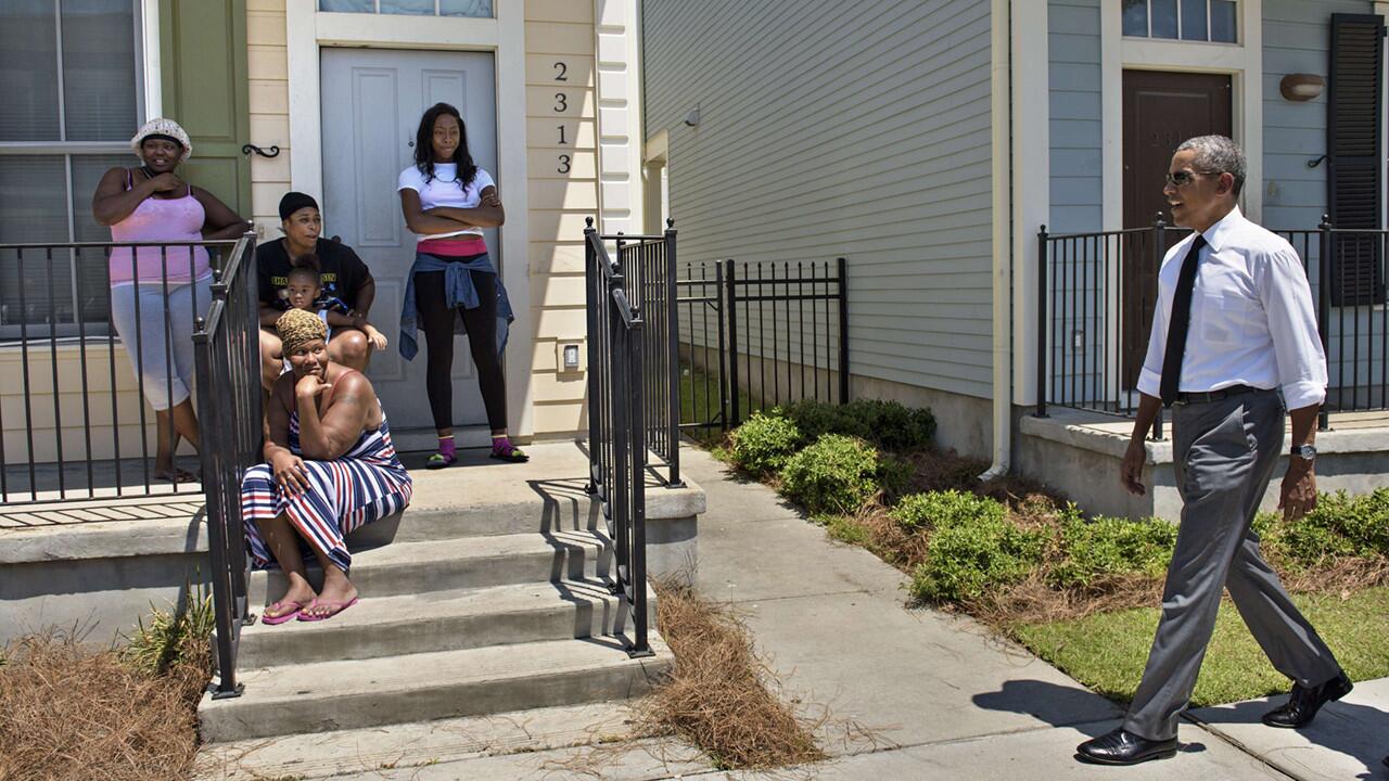 Residents watch from a stoop as President Obama tours the Treme neighborhood of New Orleans on Thursday, 10 years after Hurricane Katrina ravaged the city.