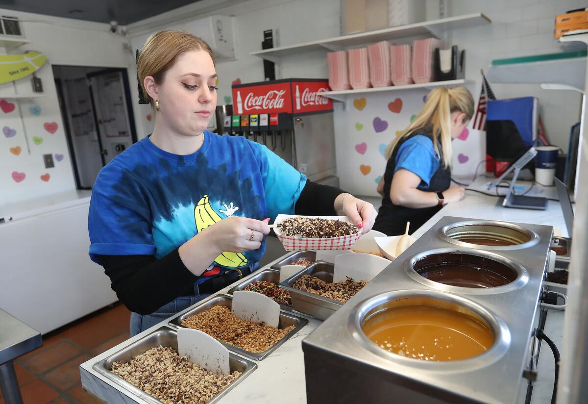 Longtime employee Fiona Zachary fills an order at the Sugar ’n Spice frozen banana stand.