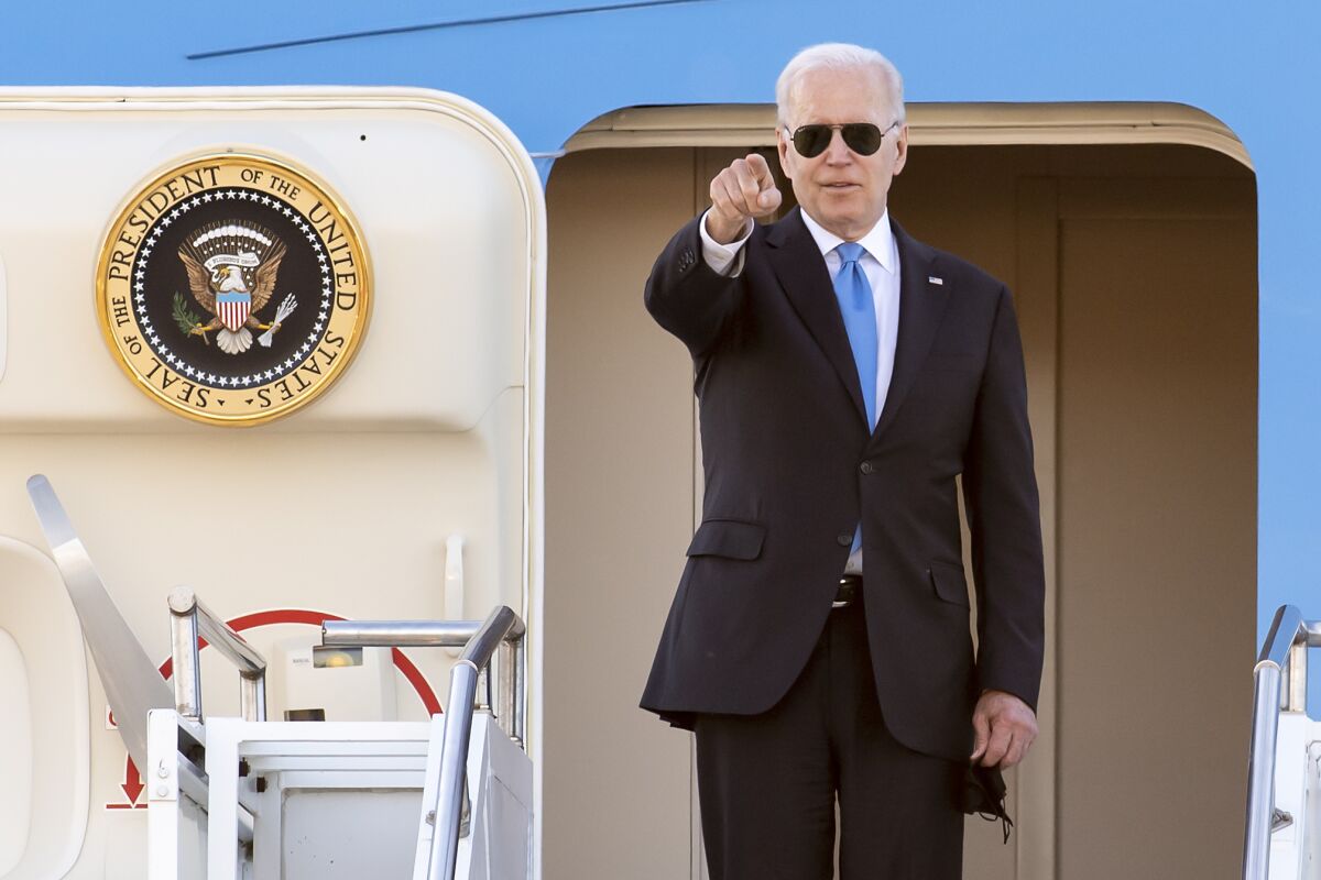 President Biden points from the doorway of Air Force One